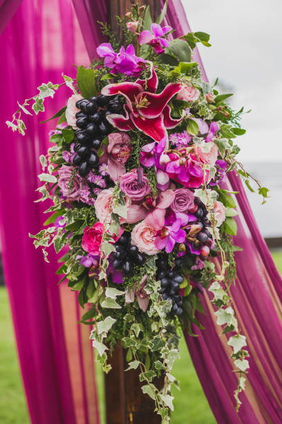 istock Wedding decorations Boho style with pink and purple orchids, roses, ivy and grape 1030071834