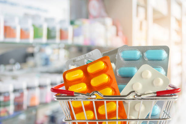 Medicine pill tablet in shopping basket with pharmacy drugstore shelves blurred background Medicine pill tablet in shopping basket with pharmacy drugstore shelves blurred background over the counter meds stock pictures, royalty-free photos & images