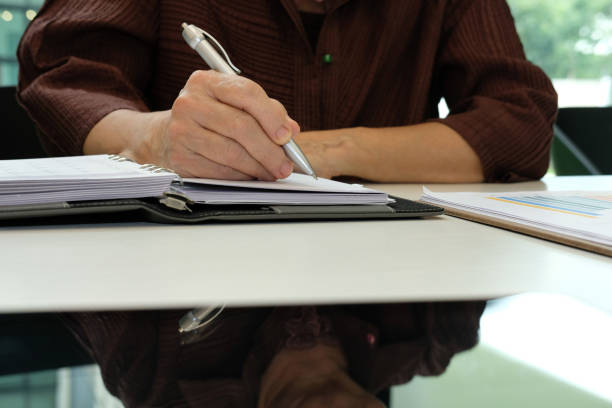 istock woman with pen organizing plan, writing note on notebook at workplace 1030072386