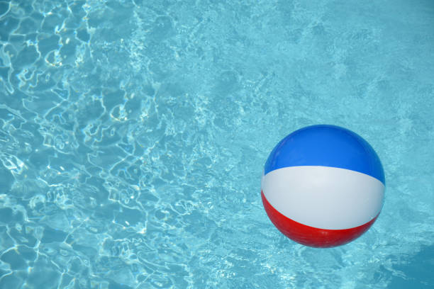 Pool floats. Beach ball in swimming pool. Summer background. Colorful beach ball floating in pool. Copy space for advertising
