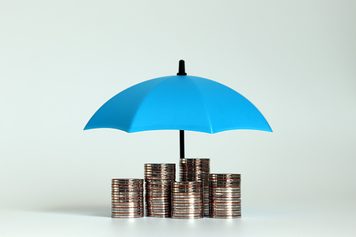 Una pila de monedas con un paraguas azul abierto. photo