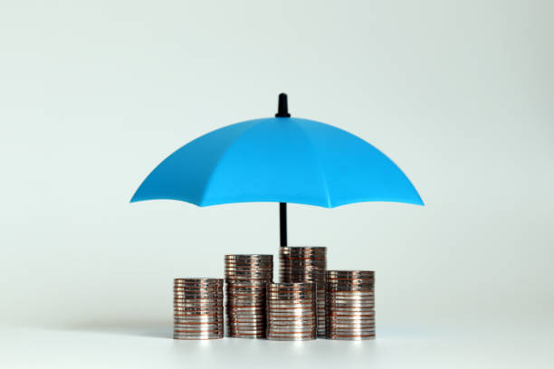 un tas de pièces de monnaie avec un parapluie ouvert bleu. - umbrella protection savings currency photos et images de collection