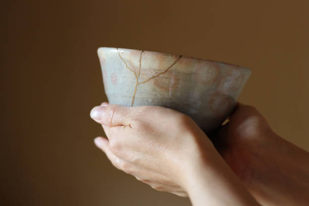 手で亀裂陶器ティーカップの修理 - copy statue ストックフォトと画像