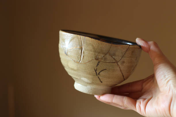 istock Repair of crack pottery tea cup with a hand 1030092600
