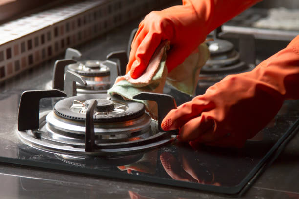 Cleaning gas stove at kitchen Hand in gloves Cleaning a gas stove at kitchen. house and kitchen cleaning service concept. gas stove burner photos stock pictures, royalty-free photos & images