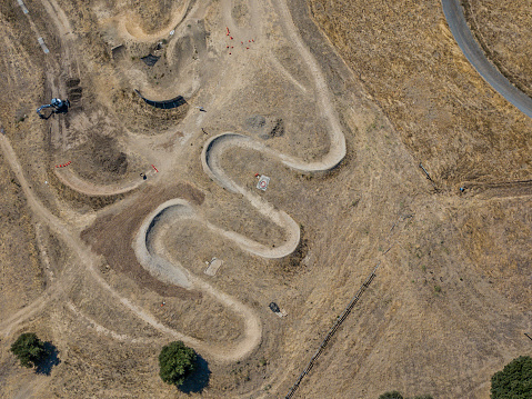 An aerial view of a BMX course on a hillside, with winding track course.\nA birdseye view of the course.
