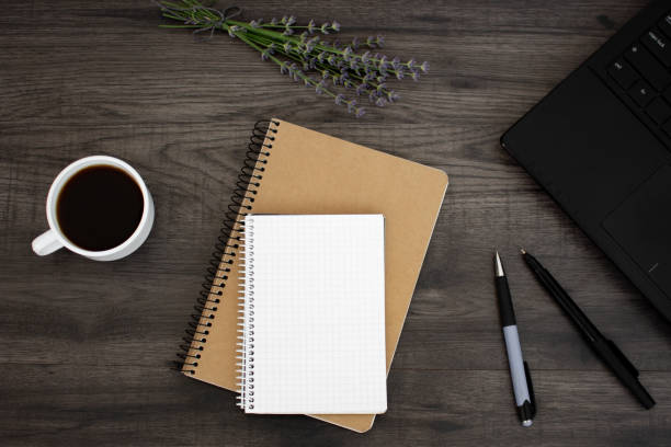 istock Open blank notepad, pen, lavender, coffee and laptop on the dark wooden table. Workplace flat lay 1030142956
