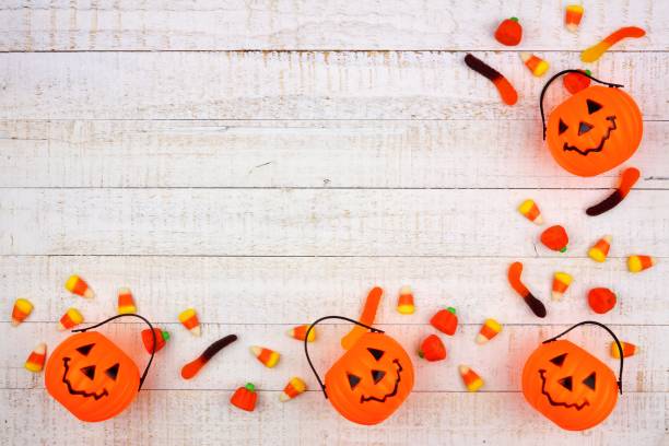 istock Halloween corner border with Jack o Lantern pails and candy on white wood 1030148430