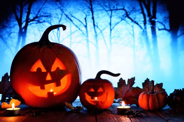 istock Halloween Jack o Lanterns against spooky blue lit forest 1030150938