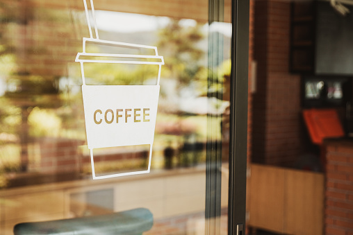 Luxury coffee shop sign on the glass door. For art texture or web design backgrund.