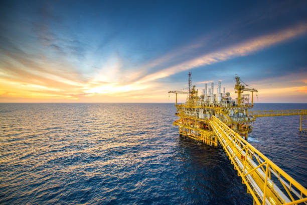 Offshore oil rig Large Offshore oil rig drilling platform at sunset and beautiful sky in the gulf of Thailand oil well stock pictures, royalty-free photos & images