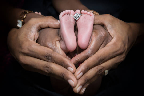 Close up human hands with newborn baby and parents