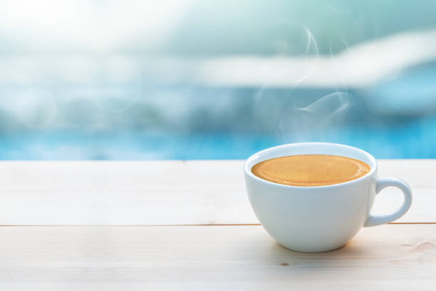 A cup of coffee at swimming pool A cup of coffee on table at swimming pool, shallow depth of field. A cup of coffee at swimming pool pool break stock pictures, royalty-free photos & images