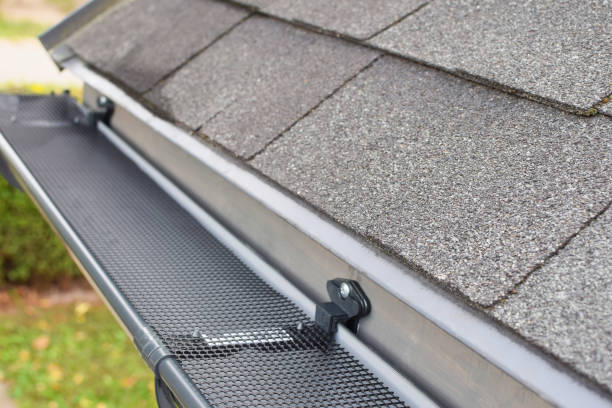 Plastic rain gutter Plastic guard over new dark grey plastic rain gutter on asphalt shingles roof at shallow depth of field. roof gutter photos stock pictures, royalty-free photos & images