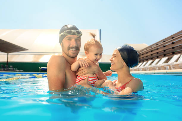 istock Happy family having fun by the swimming pool 1030187720