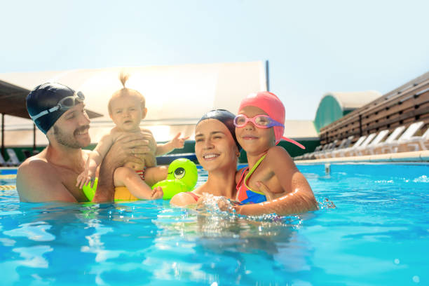 istock Happy family having fun by the swimming pool 1030187816