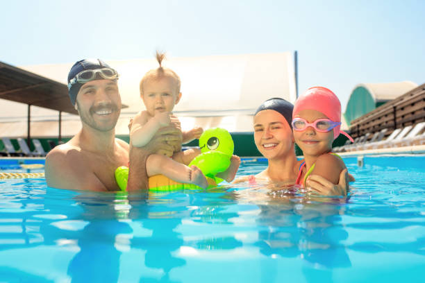 istock Happy family having fun by the swimming pool 1030187918