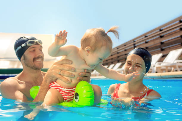 istock Happy family having fun by the swimming pool 1030187962