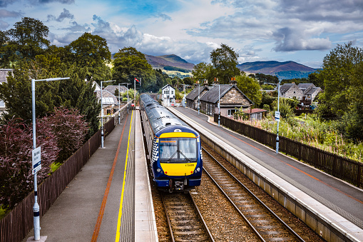 Train departing Blair Atholl railway station in the Scottish Highlands. The view is southwards and the three car diesel train is travelling from Inverness to Perth. The line is single track with twin sections at railroad stations.