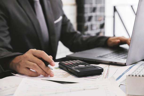 istock businessman working with laptop and business document on the work table and hand holding pen. 1030207776