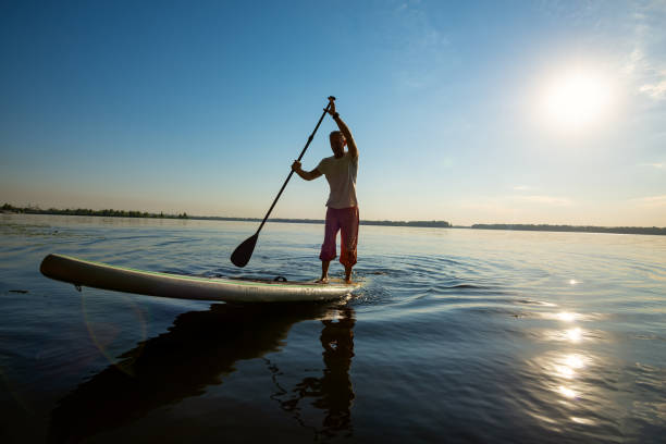 istock Joyful man paddling on a SUP board 1030211842