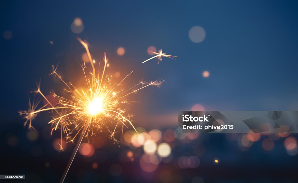 Sparkler with blurred busy city light background Sparkler - Firework Stock Photo