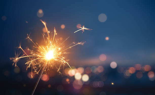 Sparkler with blurred busy city light background Sparkler with blurred busy city light background sparks photos stock pictures, royalty-free photos & images