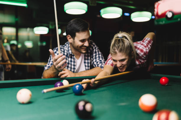 istock Young couple playing snooker together in bar 1030223010