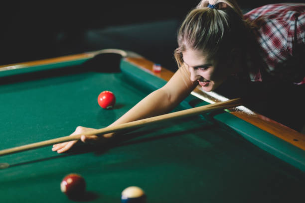istock Young attractive woman playing pool in bar 1030223228