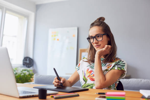 istock Pretty young graphic designer working in her home office 1030223400