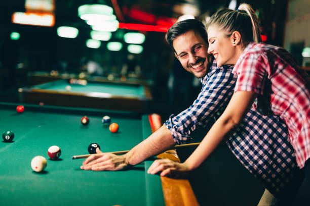 istock Young couple playing snooker together in bar 1030225450