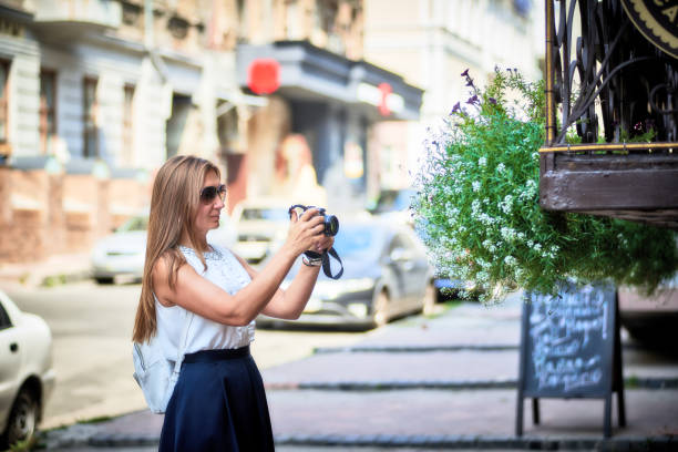 istock Young smiling woman in sunglasses with digital camera 1030228394