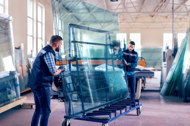 workers packaging glass sheets in warehouse - glass factory imagens e fotografias de stock