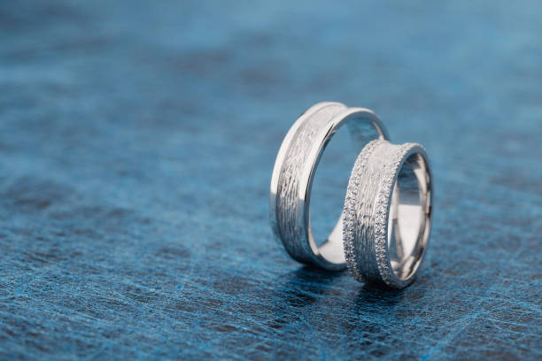 istock Two textured silver wedding rings on blue background 1030232566