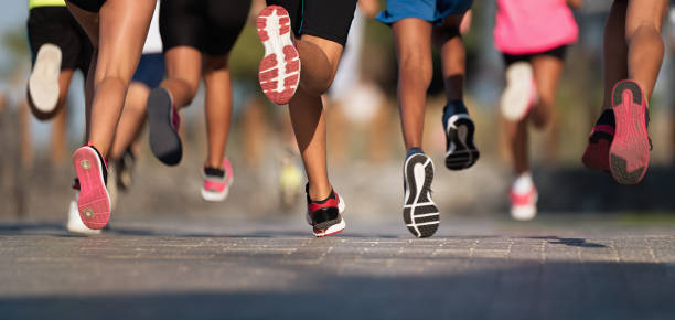 bambini in corsa, giovani atleti corrono in una gara di corse per bambini, correndo sui dettagli della strada della città sulle gambe - athletic event foto e immagini stock