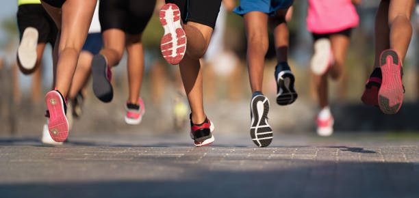 бег детей, юные спортсмены бегают в детском забеге, бегая по городской дороге подробно на ногах - running legs стоковые фото и изображения