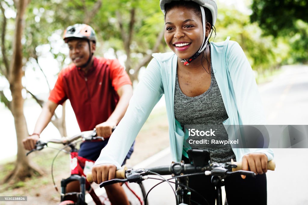 Pareja de ciclistas viajan juntos en un parque - Foto de stock de Andar en bicicleta libre de derechos