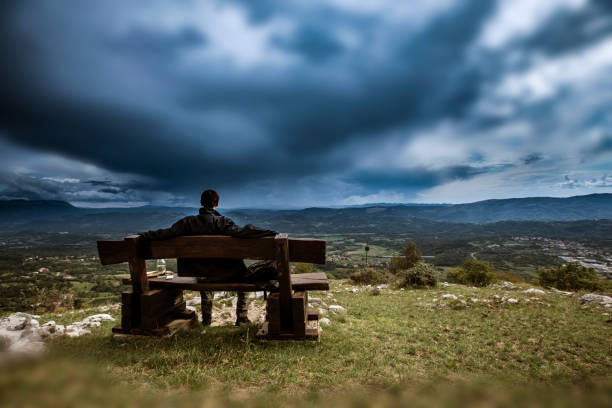 Young Adult Man Looking at View From a Bench.