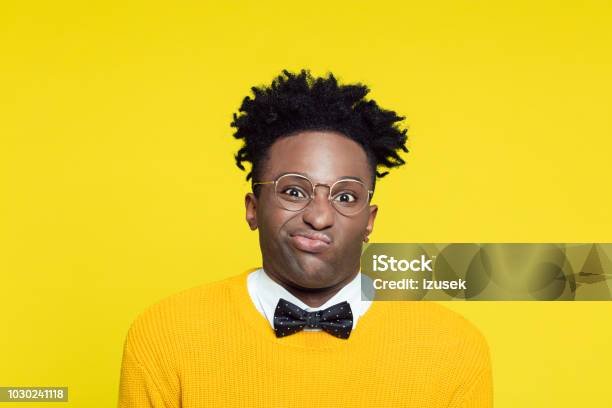 Portrait Of Disgusted Geeky Young Man In Retro Style Against Yellow Background Stock Photo - Download Image Now