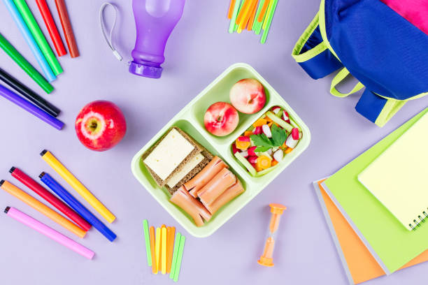 istock School concept flat lay. Kid backpack, lunchbox, water bottle, notebook, markers on wooden desktop 1030242550
