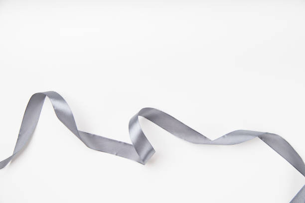 istock Curled gray silk ribbon on white background with copy space 1030242648