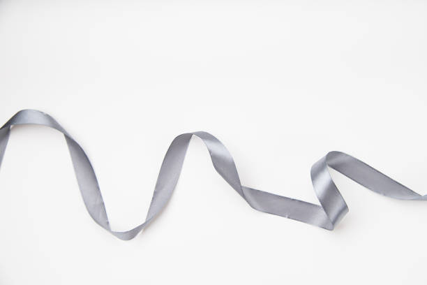 istock Curled gray silk ribbon on white background with copy space 1030242668