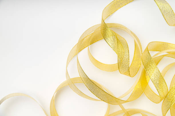 Shiny golden ribbon winded in spiral pattern on white background. Backdrop for text or announcement