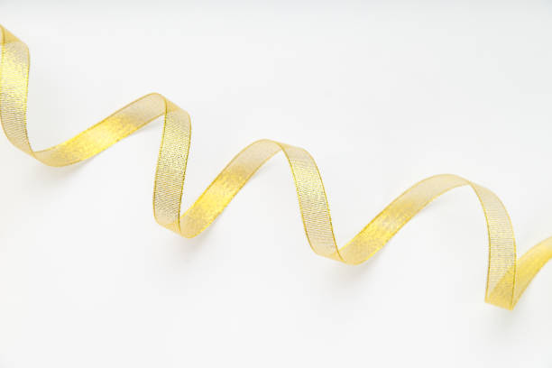 istock Shiny golden ribbon winded in spiral pattern on white background. Backdrop for text or announcement 1030242752