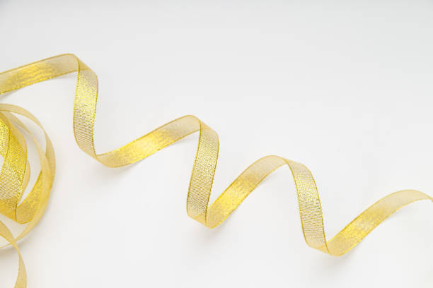 istock Shiny golden ribbon winded in spiral pattern on white background. Backdrop for text or announcement 1030242758