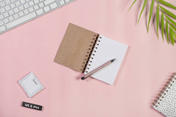 istock Directly Above View Of Open Notepad And Pen On Pink Background. 1030244036