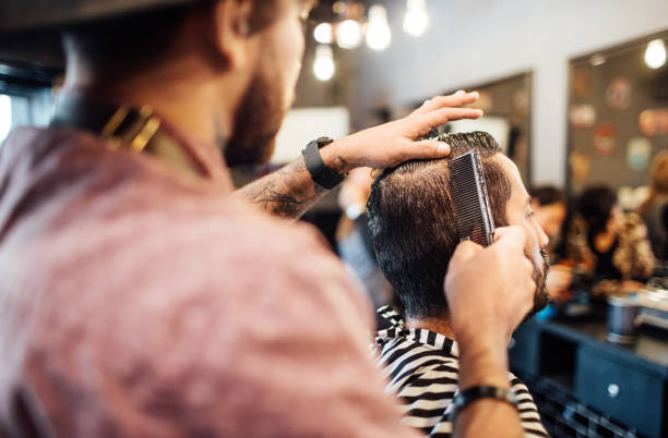 istock Young barber combing customer's hair in salon 1030246660