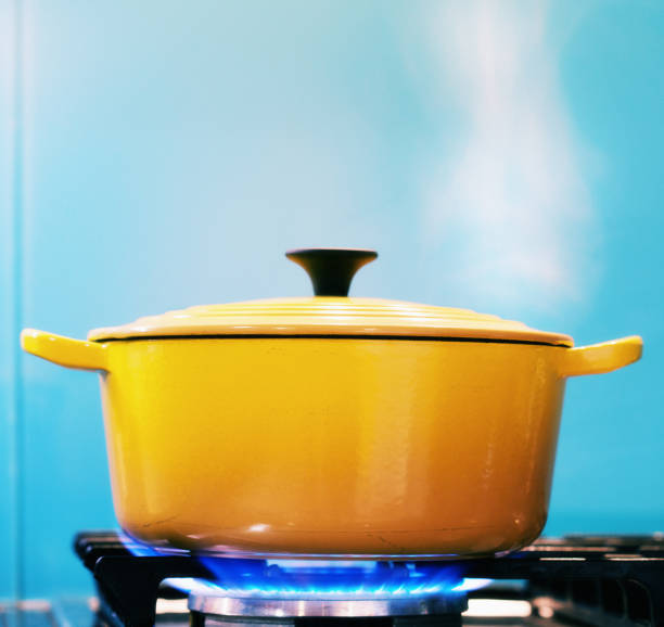 yellow lidded pot steaming on lit gas stove - panela com cabo imagens e fotografias de stock