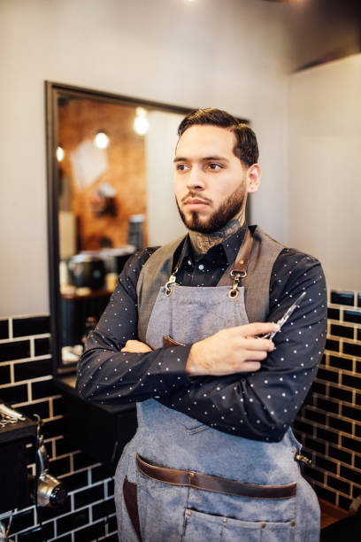 istock Confident male barber looking away in salon 1030250100