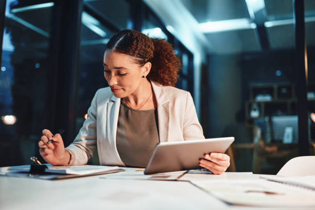 Feeling great that she's close to finishing Cropped shot of a young attractive businesswoman working late at the office persistence stock pictures, royalty-free photos & images